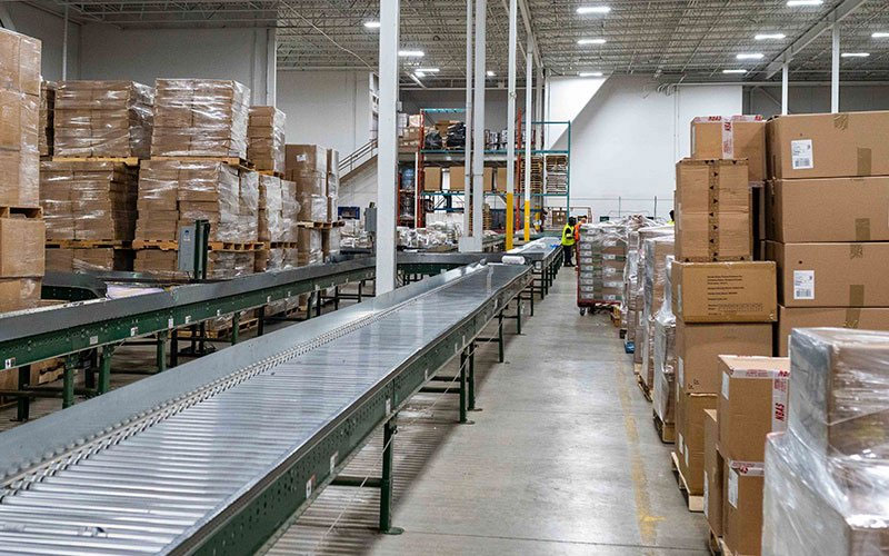 Canadian promotional logistics warehouse with conveyor sorting, pallets, and packaged freight for fulfillment Canadian promotional logistics warehouse with conveyor sorting, pallets, and packaged freight for fulfillment