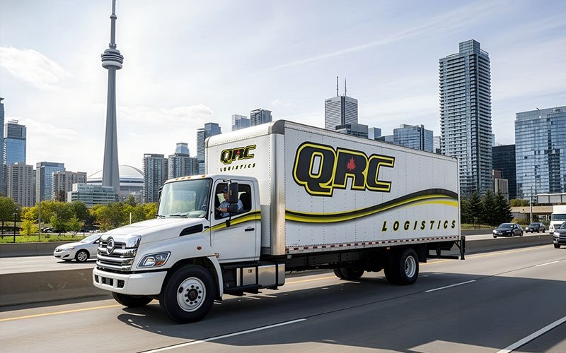 QRC Logistics truck driving through downtown Toronto with the CN Tower in the background, representing Ontario retail distribution and local freight delivery. QRC Logistics truck driving through downtown Toronto with the CN Tower in the background, representing Ontario retail distribution and local freight delivery.
