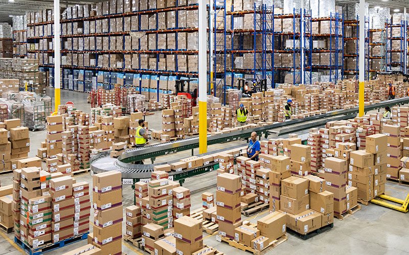 Warehouse team organizing boxes and inventory on conveyor lines and pallet racking, representing QRC Logistics warehousing and pick-pack services. Warehouse team organizing boxes and inventory on conveyor lines and pallet racking, representing QRC Logistics warehousing and pick-pack services.