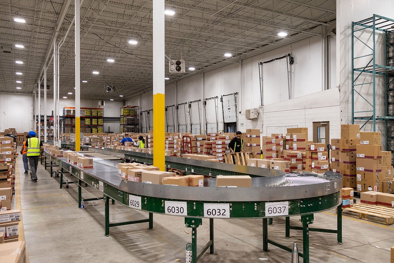 Warehouse team processing returned products along a conveyor line